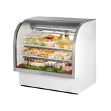 Curved glass deli case from True Refrigeration showcasing assorted food items